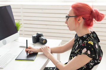 Business, designer and animator concept - young woman illustrator or artist with pink hair draws on...