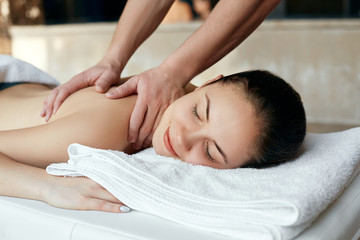 Fototapeta na wymiar Masseur doing massage on woman body in the spa salon. Beauty treatment concept. Body care. Girl having massage in the spa salon