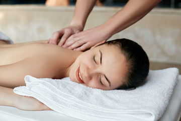 Fototapeta na wymiar Spa Massage. Beautiful woman relaxing in spa salon. Body care. Spa body. Cosmetology. Girl having massage in the spa salon