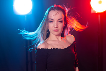 Naklejka premium Nightclub, nightlife and people concept - Young woman posing in the dark