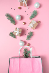Package with different christmas decoration on pink background. New year concept.