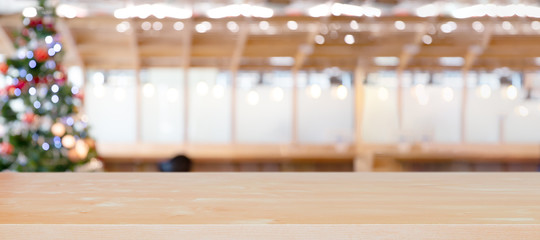 Christmas holiday background with empty wooden table top over festive bokeh light decorate on xmas tree.