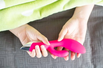 Adult sex toy with female hand in sexual health care concept.