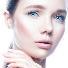 Close-up beauty face of young model woman with perfect skin, hand near face, natural make-up, blue eyes