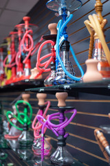 Fototapeta na wymiar Colorful Hookah water pipes on shelf display