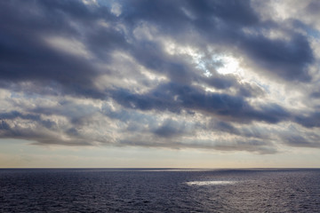 rays of the sun filtering through the clouds over the sea