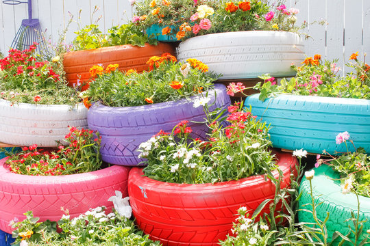 A flower garden featuring beds of reused and painted tires