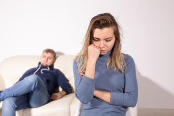 domestic violence, abuse and family concept - crying woman and her husband on the background