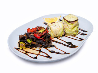 Fish rolls with stewed vegetable stew with sauce and a slice of lemon