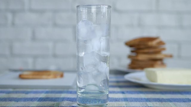 Image with a Glass from the Kitchen Table Filled with Cube Ice and Fresh Water