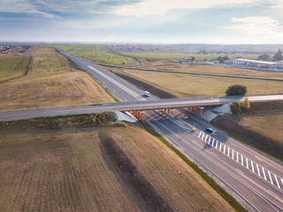 Aerial drone flight over road junction. Top view. Summer highway crossroad