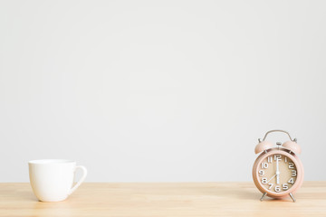 Alarm clock on office desk. concept time to work. six o'clock in the wake up. coffee cup with alarm...