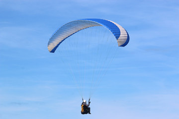 Paraglider flying blue wing