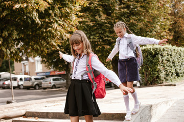 Back to school. Schoolgirls have fun.Children in the schoolyard