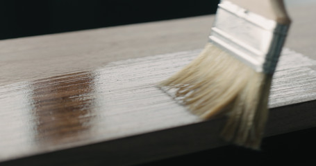 applying oil finish with brush to black walnut board