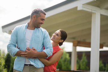 Loving beautiful wife hugging her strong handsome man