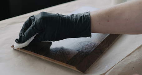 woodworker applying oil finish to walnut end grain wood board