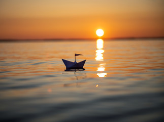 Fototapeta na wymiar Papierschiff im Sonnenuntergang