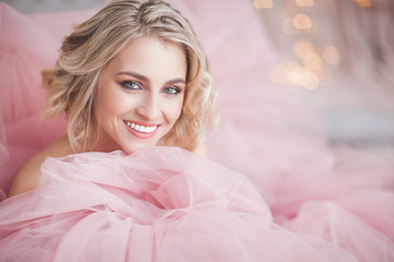 Beautiful young blond woman closeup. Lady on christmas background. Portrait of pretty female indoors.