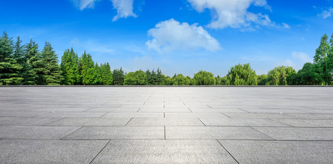Empty square floor and green woods natural scenery in city park - obrazy, fototapety, plakaty