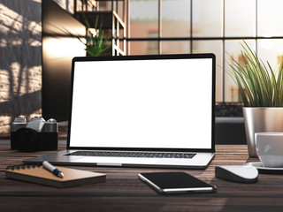 Fototapeta premium Laptop with blank screen on wooden desk in loft office interior with natural light