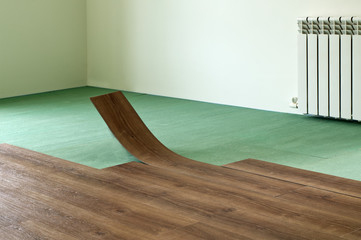 Quartz vinyl flooring. Laying of dark wood color during interior repair.