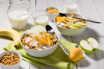 Cereal cereal with fruit and yogurt on a white wooden background. Healthy breakfast top view