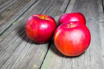 Red apples on a wooden background