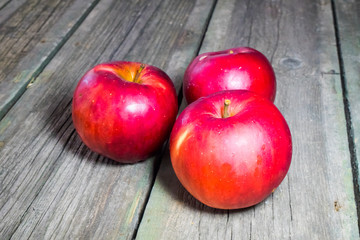 Red apples on a wooden background