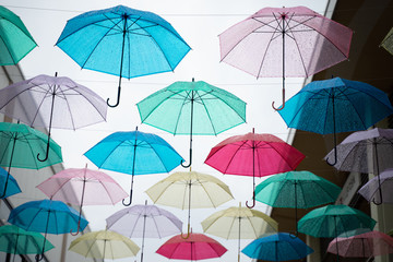 Fototapeta na wymiar Multi-colored umbrellas in the sky on heavy rainy days
