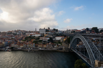 Fototapeta na wymiar View to the old city of Porto with the D. Luis bridge and colorful buildings. cloudy sky.