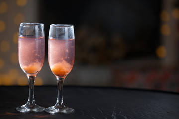 Glasses with a pink drink on a background of illumination