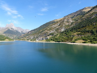 Naklejka premium Pueblo en lago entre montañas