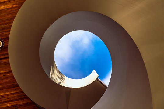 A spiral staircase leading to a blue sky at a public access garden in Docklands, Melbourne, Australia