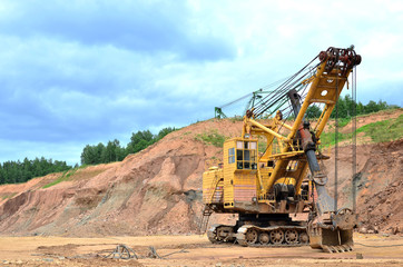 Huge mining excavator in the limestone open-pit. Biggest digger working in dolomite quarry. Largest tracked machine with electric shovel. Heavy duty electric-powered mining equipment - Image