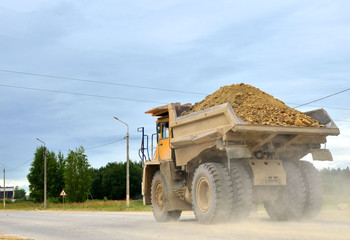 Big yellow dump truck working in the limestone open-pit. Loading and transportation of minerals in the dolomite mining quarry. Belarus, Vitebsk, in the largest i dolomite deposit, quarry "Gralevo"