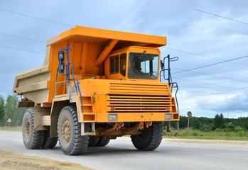 Big yellow dump truck working in the limestone open-pit. Loading and transportation of minerals in the dolomite mining quarry. Belarus, Vitebsk, in the largest i dolomite deposit, quarry "Gralevo"
