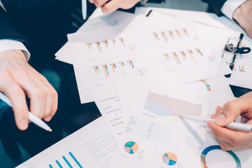 Financial research. Business partners discussing statistics, working with graphs at meeting.
