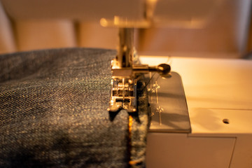 Jeans hem in the sewing machine ready to get cut