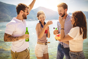 Friends at the beach drinking cocktails having fun on summer vacation