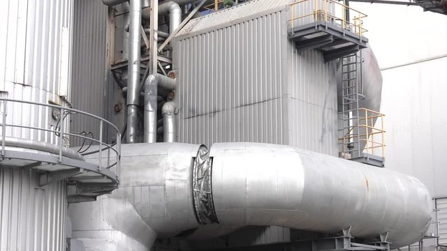 Equipment, pipelines and stairs installed outside of a modern industrial power station. Large industrial pipes in a thermal power plant