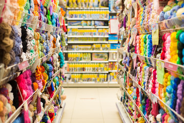 Shelves with colorful yarn balls at knitting store. Shop Needlework, counters with colored yarn....