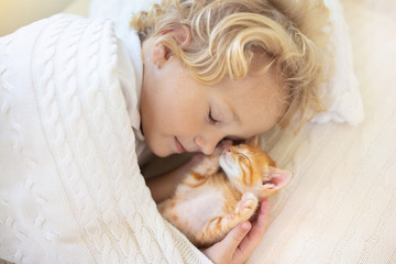 Obraz na płótnie Canvas Baby boy sleeping with kitten. Child and cat.