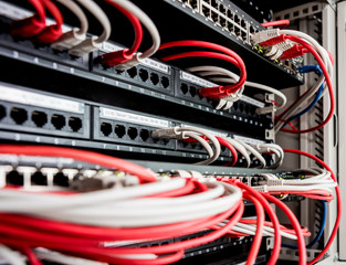 Network switch and ethernet cables in red and white colors. Data Center