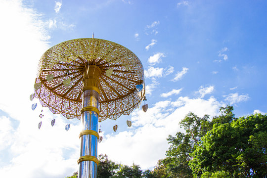 Golden umbrella of Phra borommathat Chedi Si Phu Pha Sung (Phra That Chom Pha) Phupha Sung Forest Temple and blue sky bright background.