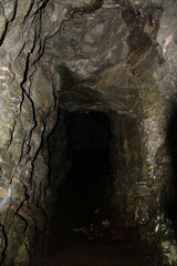 the entrance to the old, mysterious, dark stone cave in the mountains of Norway