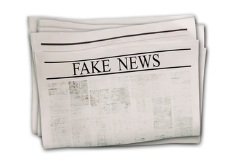 Newspaper with headline Fake News isolated on white background.