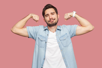 Portrait of proud satisfied handsome bearded young man in blue casual style shirt standing in body...