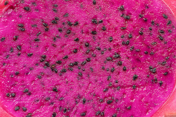 Exotic pink dragonfruit cut macro photo on background. Dragon fruit closeup. Pitahaya texture photo. Sweet tropical fruit, juicy pitaya cut
