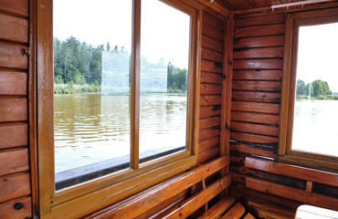 Photo of a beautiful river wooden house in the summer on the lake. Inside view. Made in nature.
